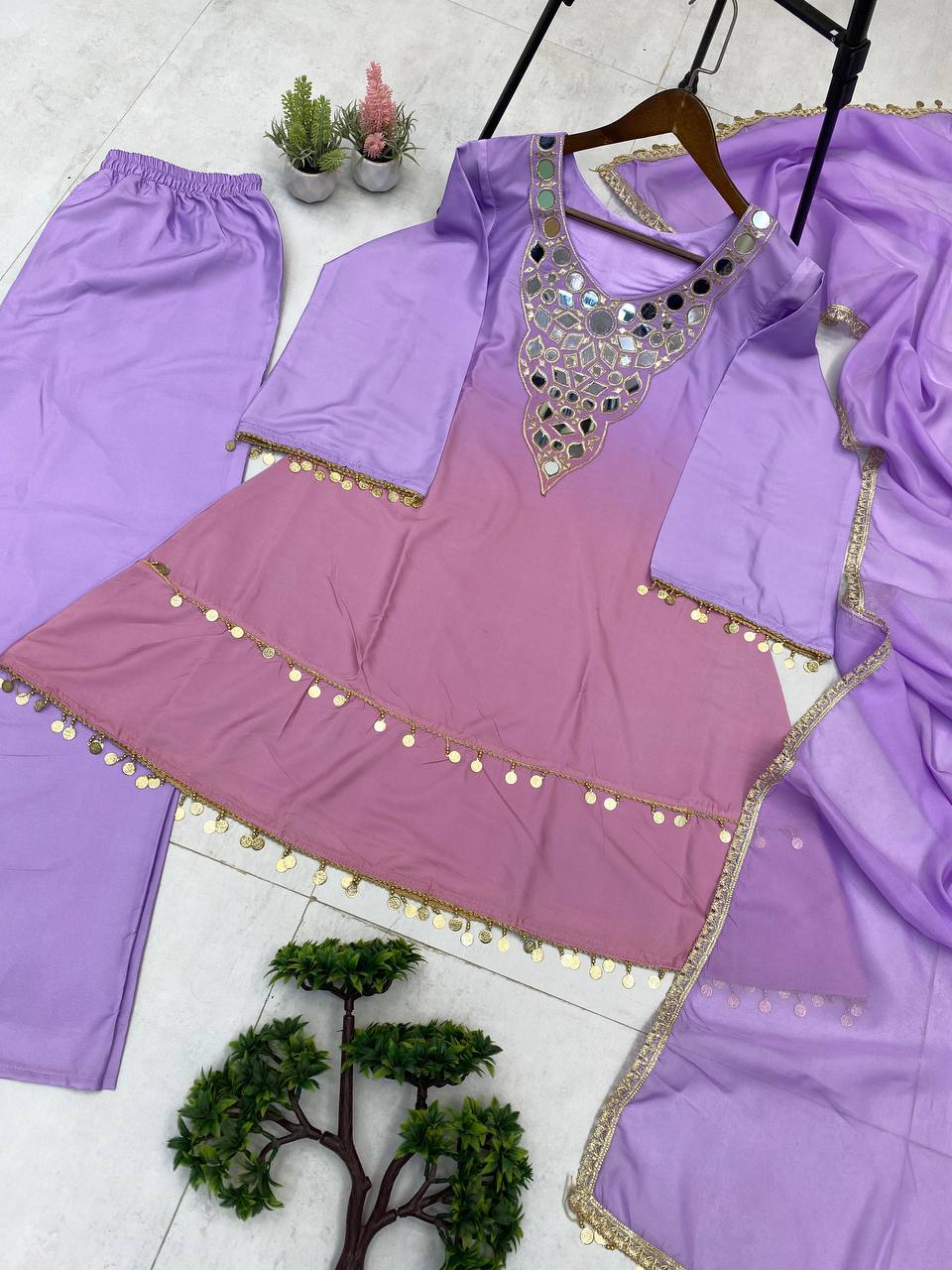 Purple traditional outfit with embellishments on a white floor.