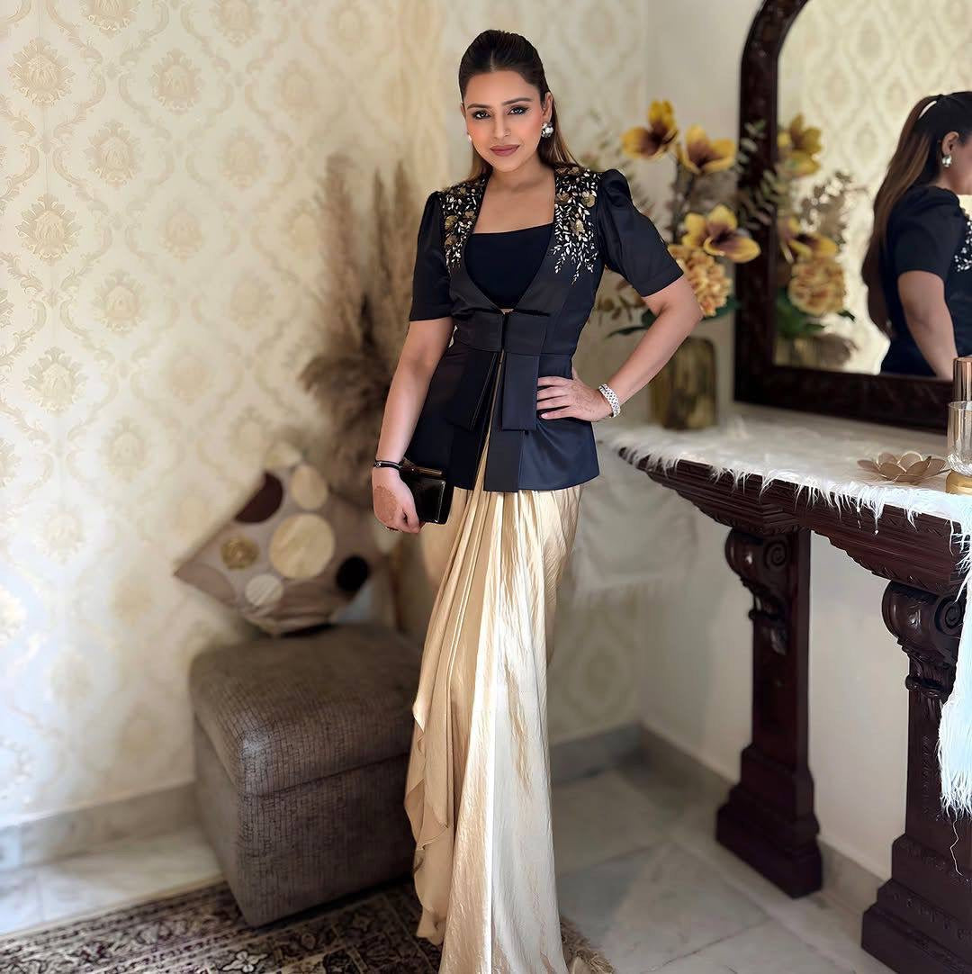 Woman in a black and white outfit standing in a room with decorative elements.