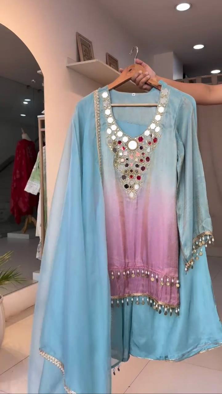 Light blue and pink traditional outfit with embellishments on a hanger.