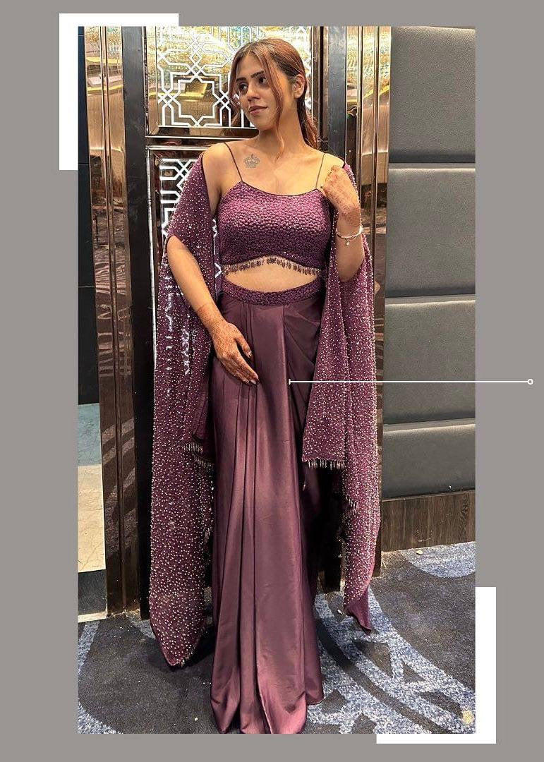 Woman in a mauve saree with a matching blouse in an indoor setting.