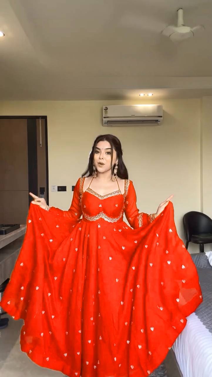 Person wearing a red traditional outfit in an indoor setting